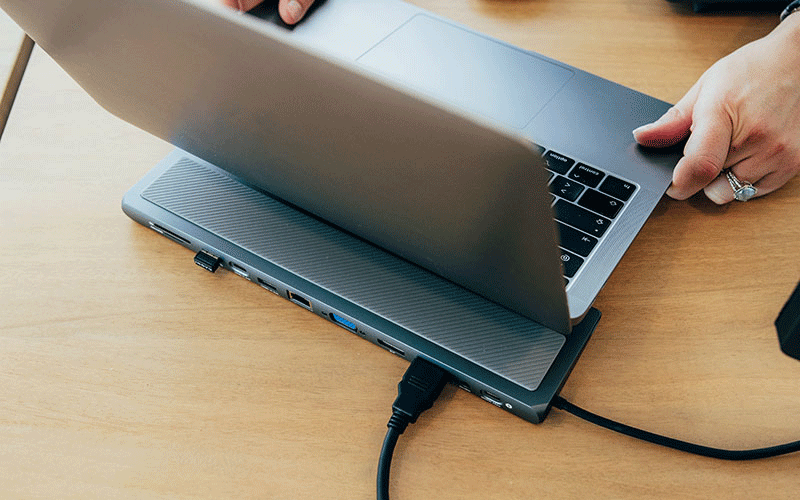 Station d'accueil branché qui fait office de support pour pc portable sur un bureau